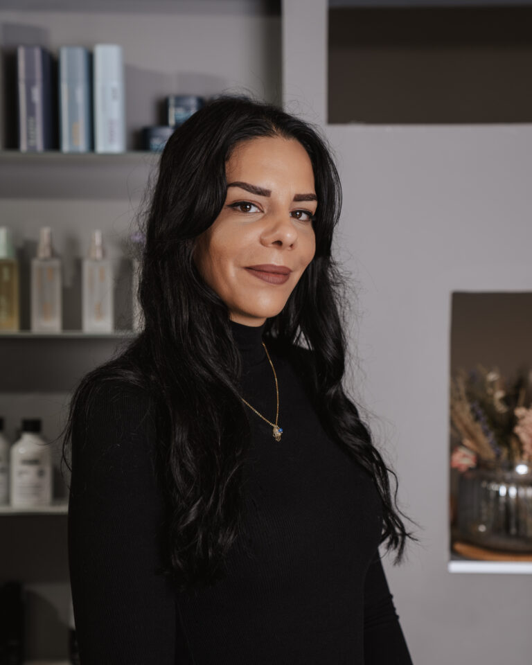 7 hchairdesign 7 Wir lieben Haare Yasmin, Friseurin bei Helena Conzen Hairdesign, lächelnd im Salon in Bochum.