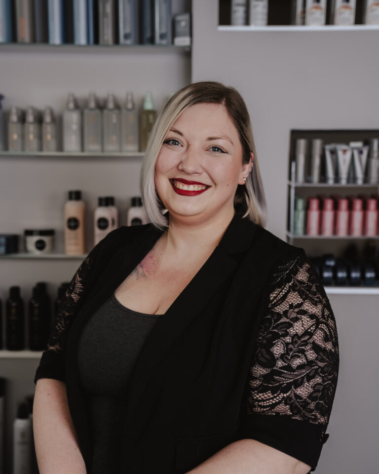 2025 HC Hairdesign 1 Wir lieben Haare Friseurin Tatjana von Helena Conzen Hairdesign in Bochum, spezialisiert auf Calligraphy Cut, Blondlooks und Steckfrisuren, lächelt im Salon in die Kamera.