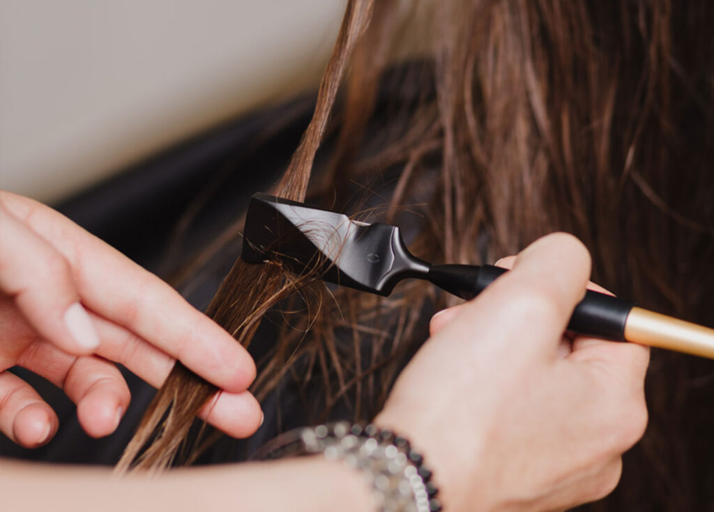 220722 menschen im salon LP Bild Calligraphy Cut jetzt neu bei uns – kostenlos testen im Mai & Juni! Friseur schneidet Haare mit Calligraphen während eines Calligraphy Cuts im Salon in Bochum