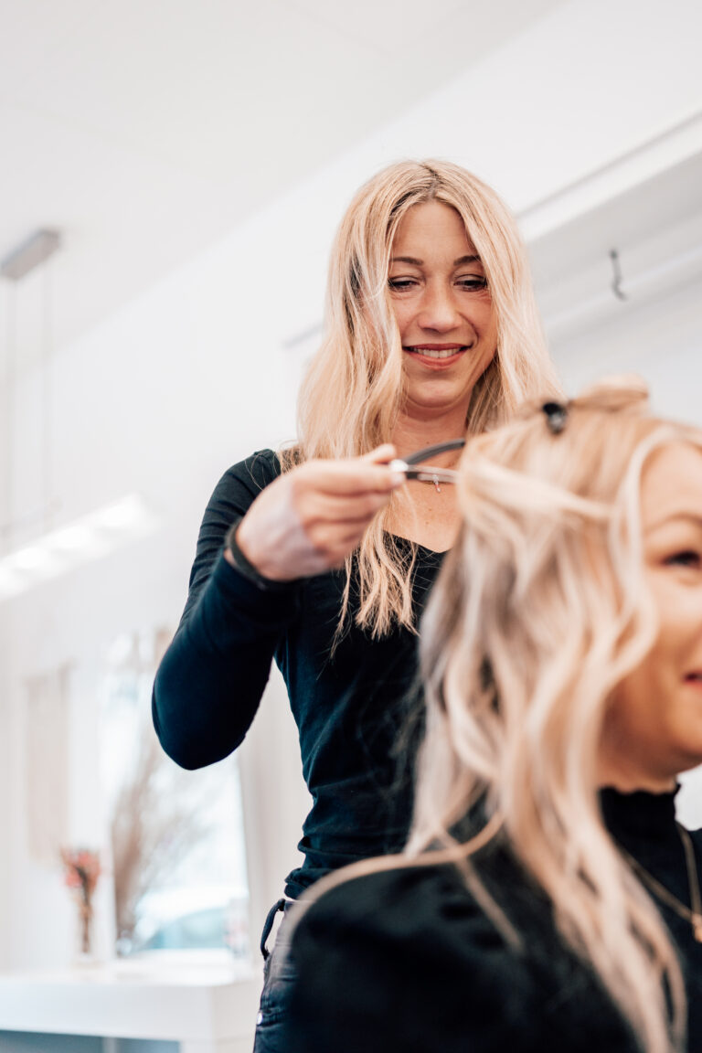 20220425 helenaconzen hairdesign 61 von 1 Wir lieben Haare Friseurin trägt Balayage-Farbe auf blonde Haare einer Kundin auf